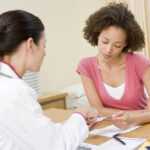 woman discussing aldosterone hypertension test results with her physician at a clinic