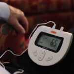 Person using RESPeRATE device-guided breathing stress relief session at home
