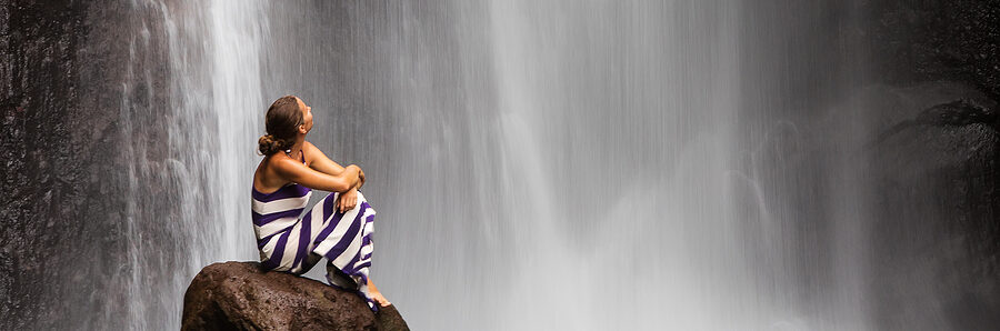 woman sitting watching a waterfall