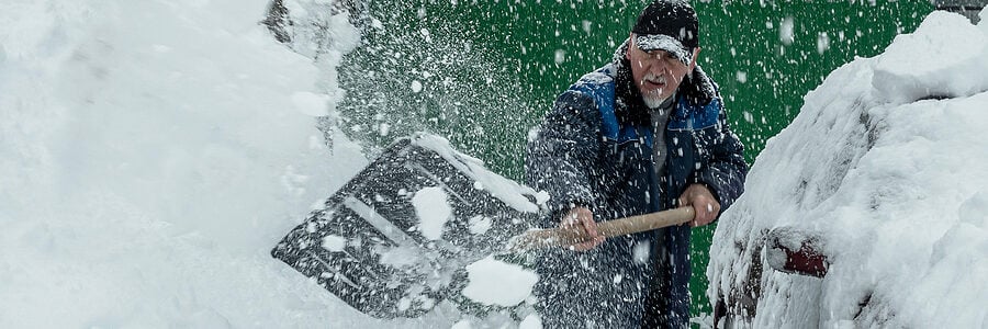 Man shoveling snow in driveway